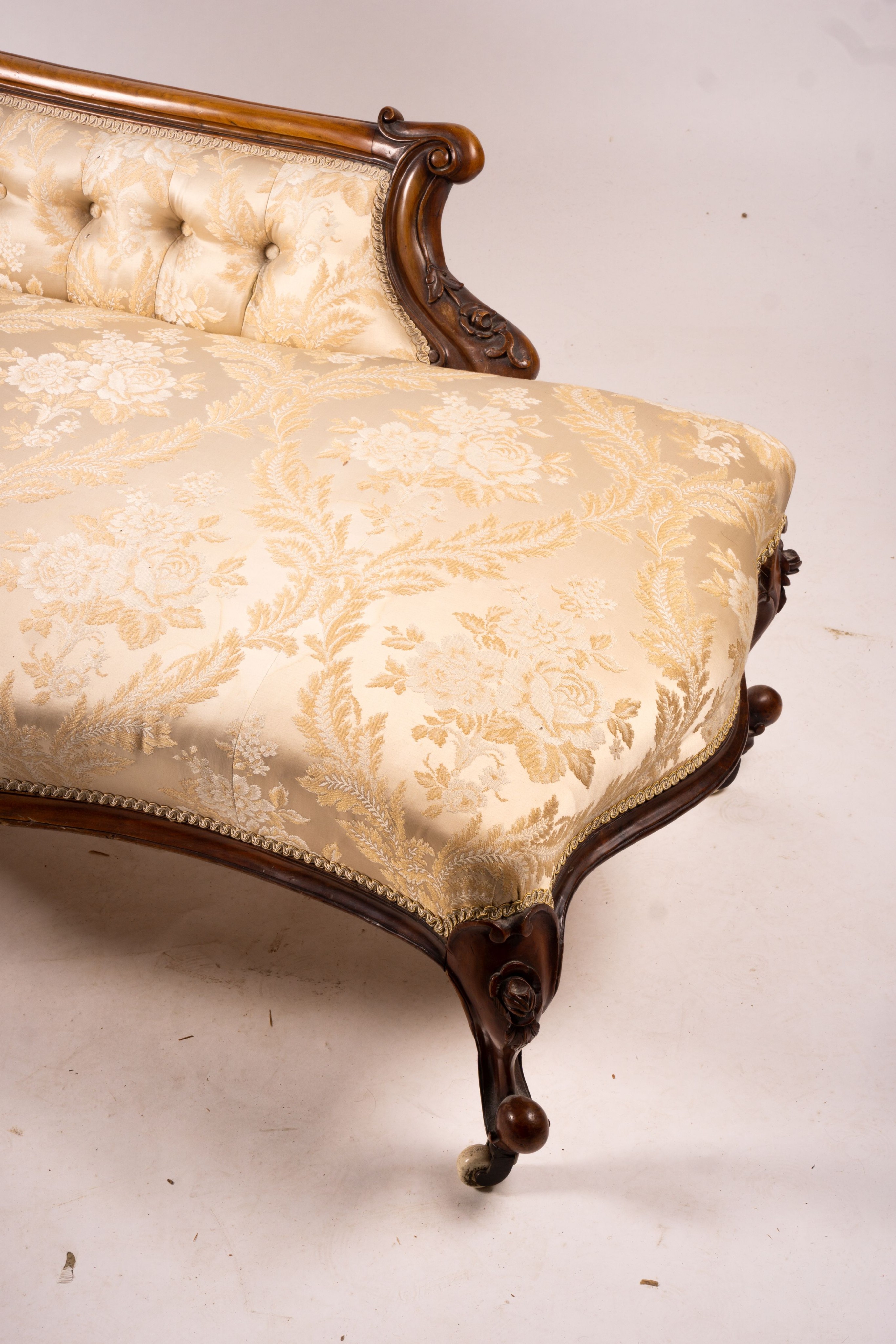 A late Victorian carved walnut three piece salon suite, comprising chaise longue, open armchair and nursing chair